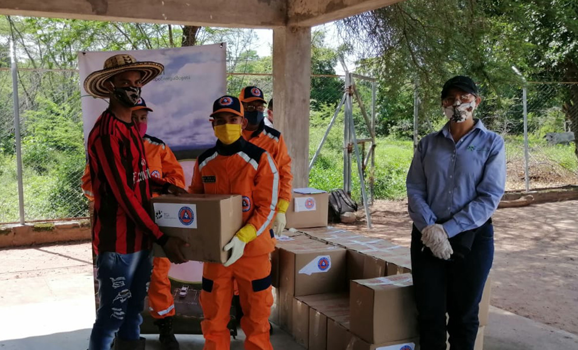 Young Civil Defense members hand over humanitarian aid package to another young man.