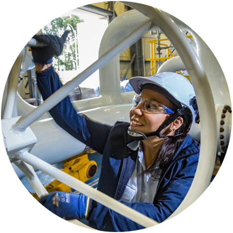 Woman smiles as she operates a machine.