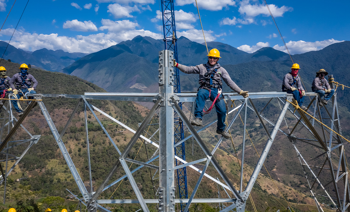 Five GEB workers sitting on an electric tower steel structure.